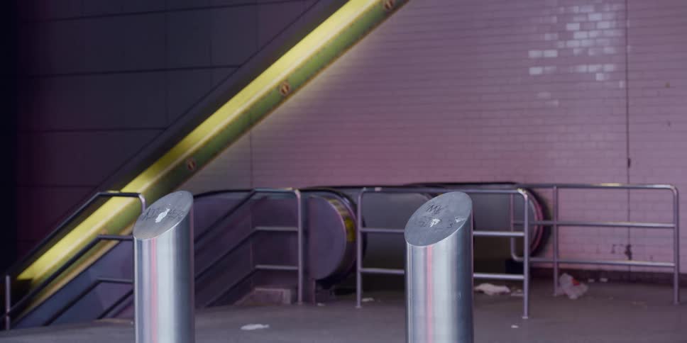 Multiple people walk past an escalator