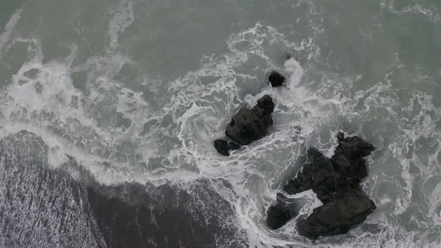 Rough waves breaking on a rocky shore