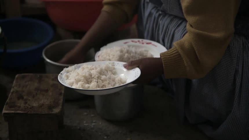 Rice and other food being placed into bowls