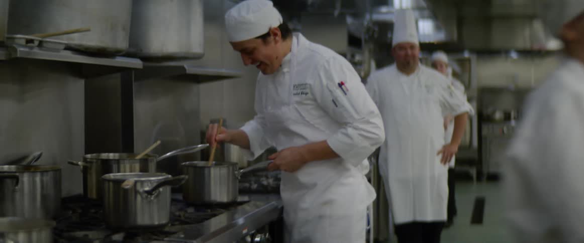 Cooks cooking in a large commercial kitchen