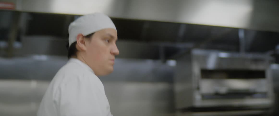 A chef walks through a kitchen