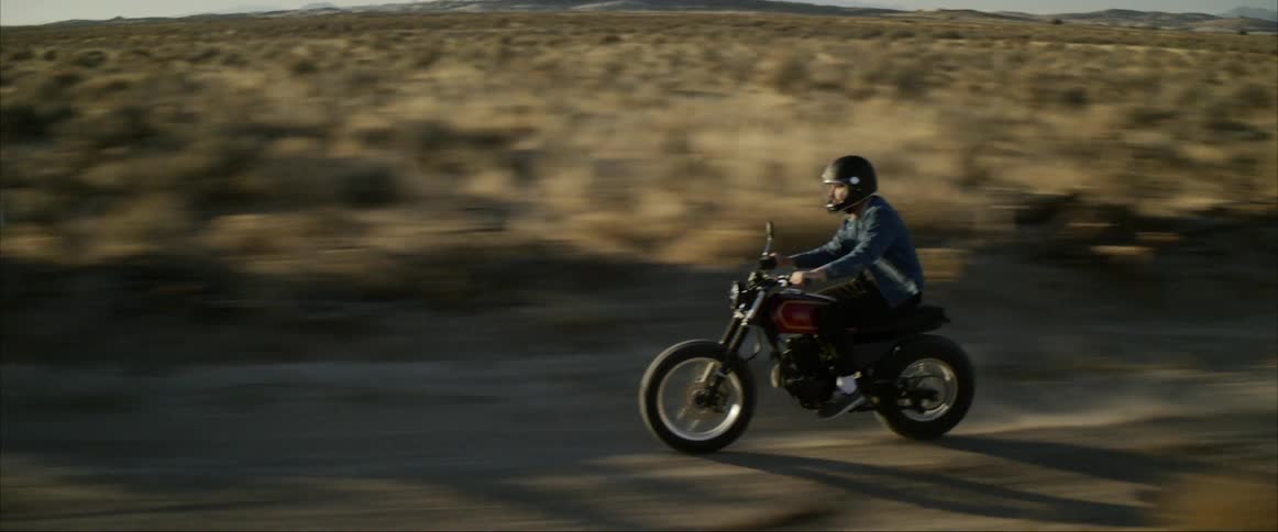A man rides a motorcycle down a street