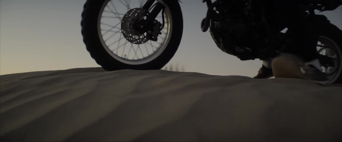 A person riding a motorcycle on a sandy dune