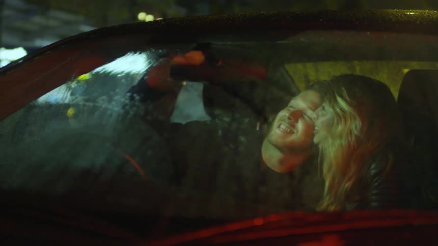 A man and woman take a selfie in their car