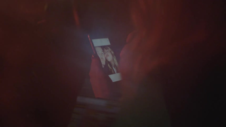 A woman looks at a photo on her cell phone