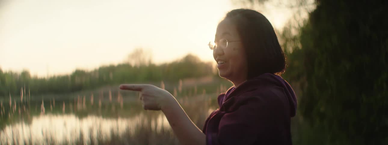A woman happily stares at the water