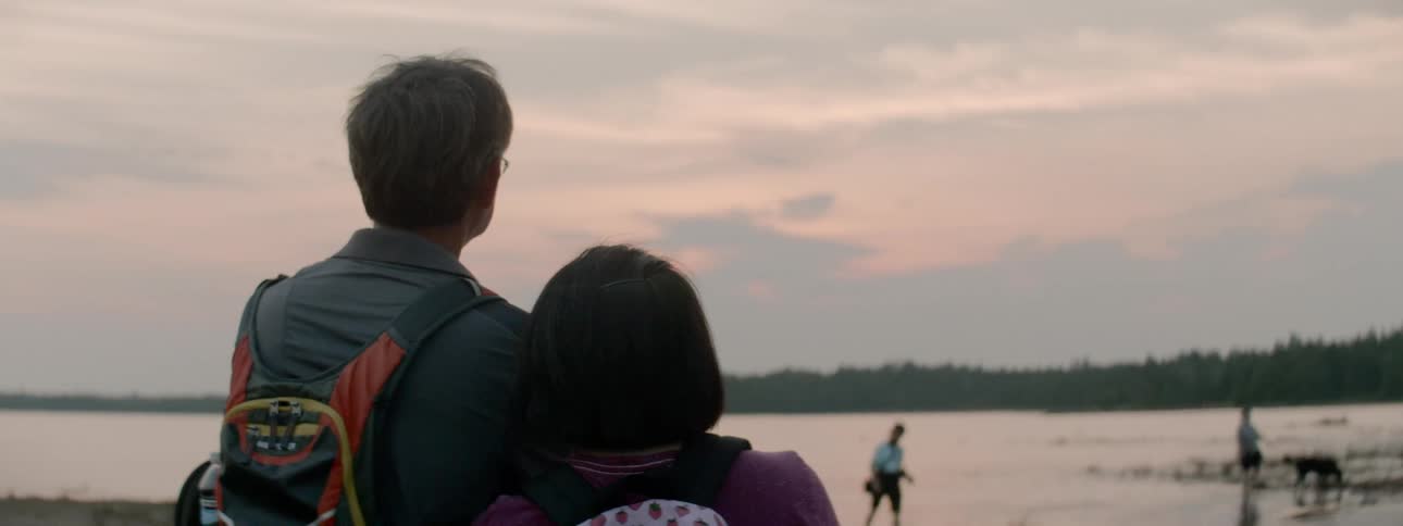 Couple cuddles while watching scenery at beach