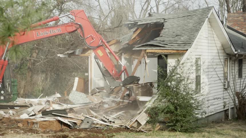 House being torn down with hydraulic excavator