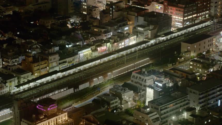 A train travels through Tokyo at night