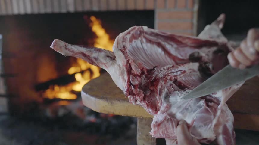 A man cuts a large raw piece of meat