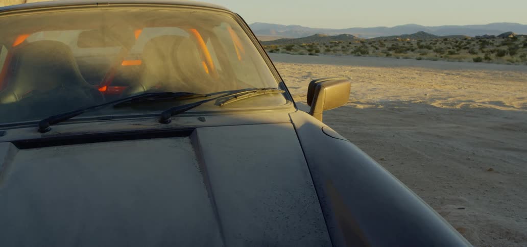 A car sits on a sandy beach