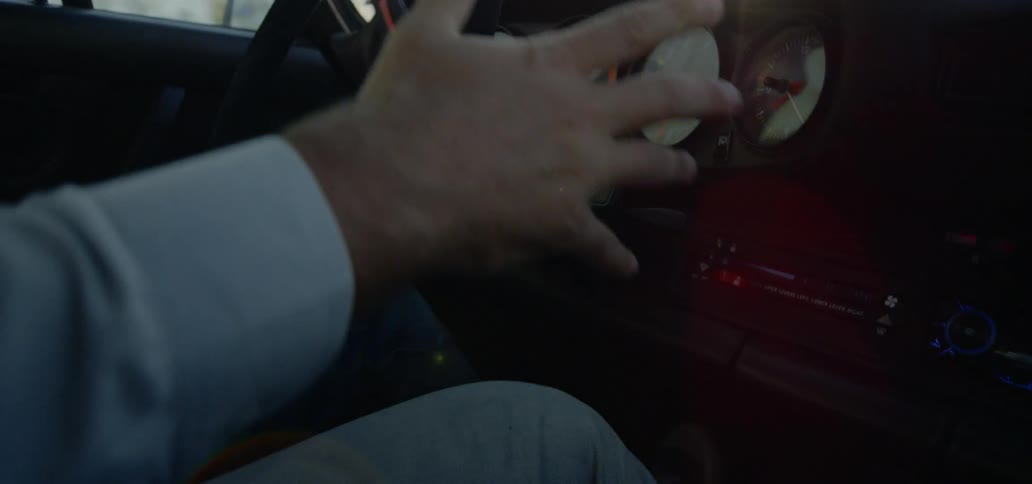 A driver turns the steering wheel then releases to let the car straighten out while driving on a sunny day