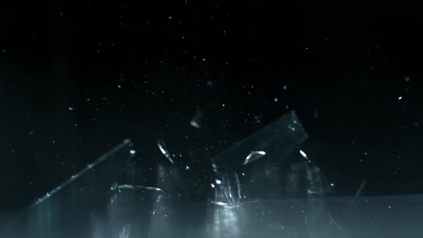 A square piece of glass falls and hits a hard surface and shatters