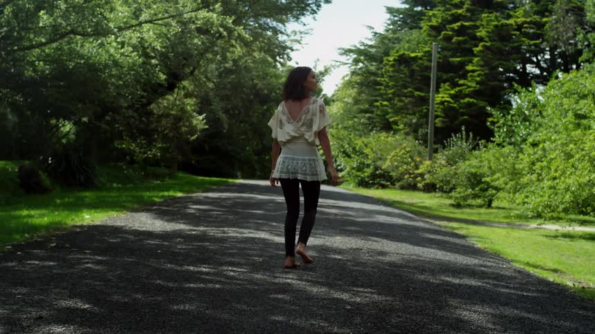 Woman walking on a road on a bright day