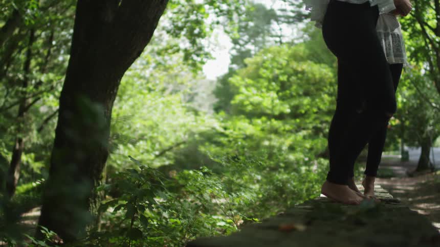 Two people stand barefoot on a log