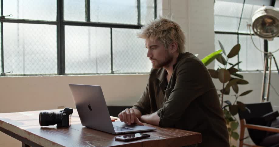 A man opens a laptop and begins working