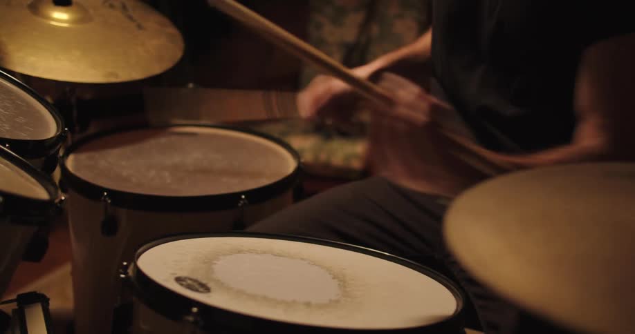 A man drumming in a dimly lit room
