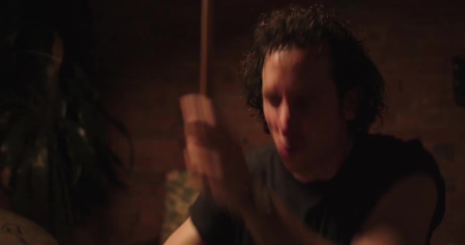 A man sitting playing the drums