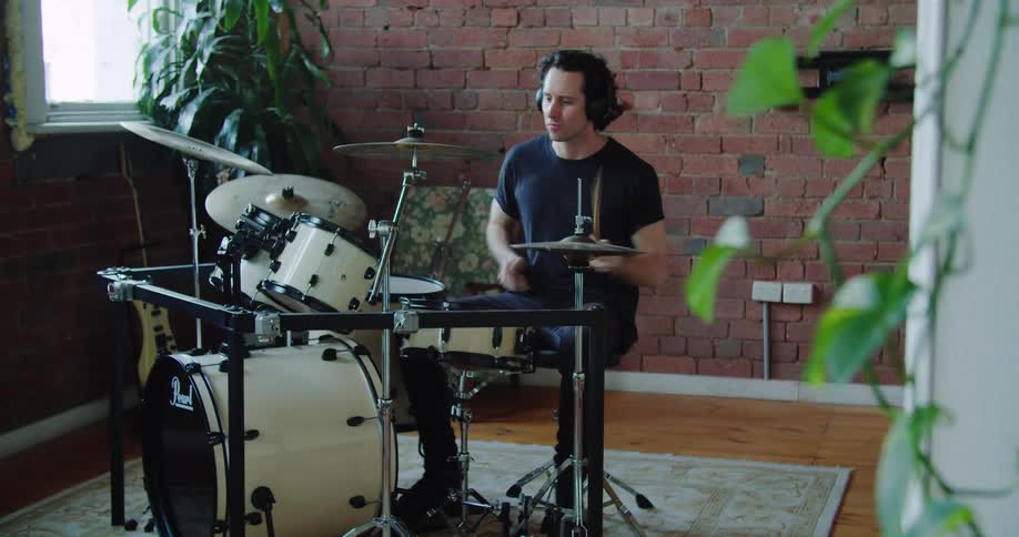 Musician playing drums on a room inside house