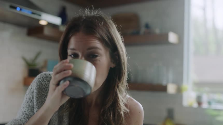 A woman drinks from a mug