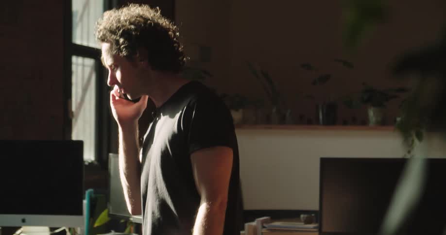 A man paces while talking on a cell phone