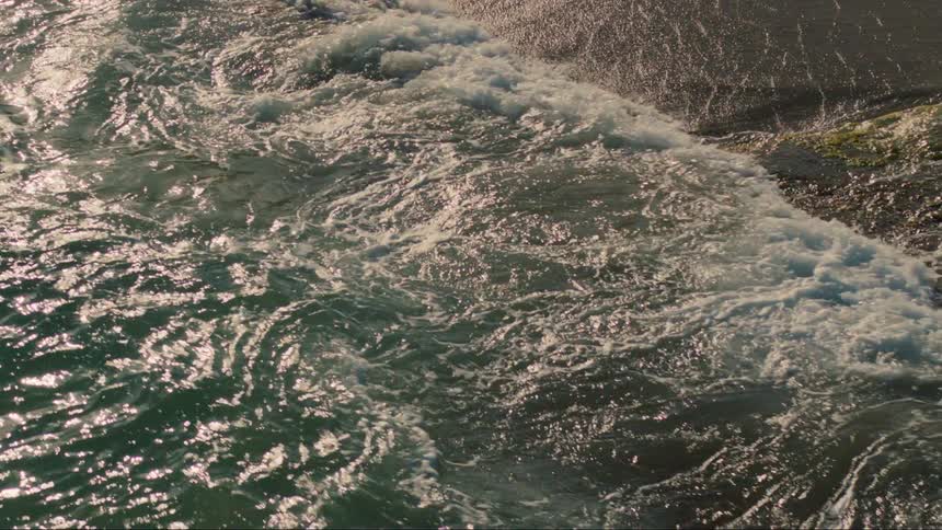 Surf rolls in over retreating waves