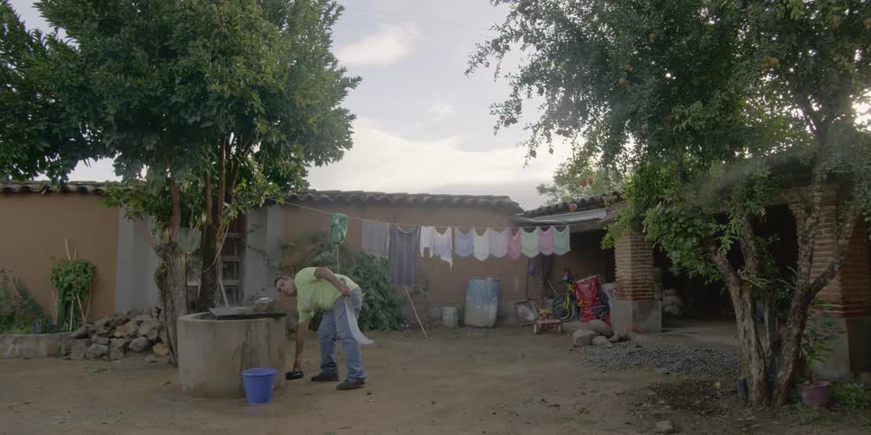 A man cleans a saw outside