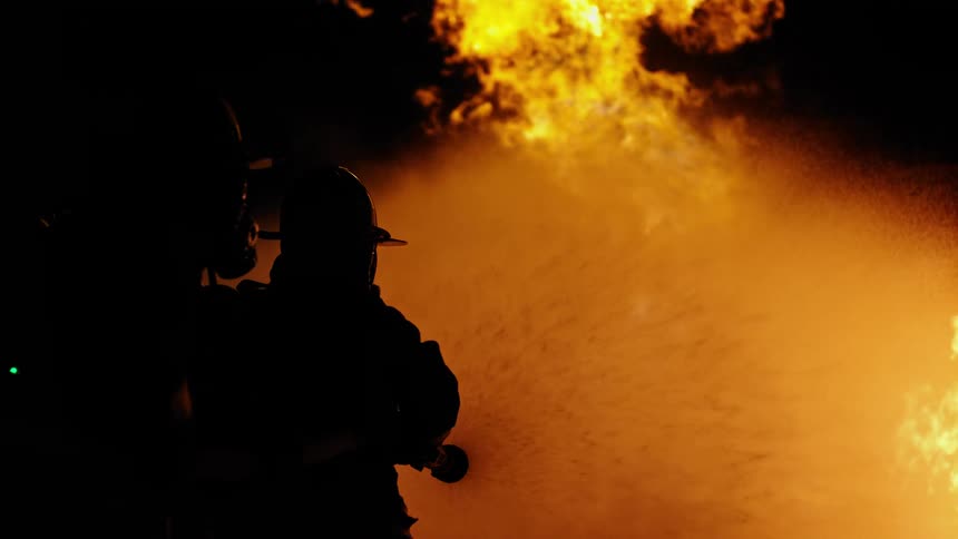 A firefighter sprays water on a fire