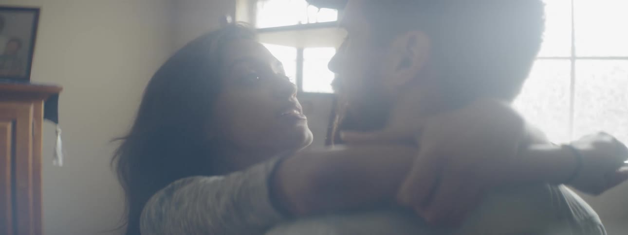 A man and a woman talk to one another while embracing