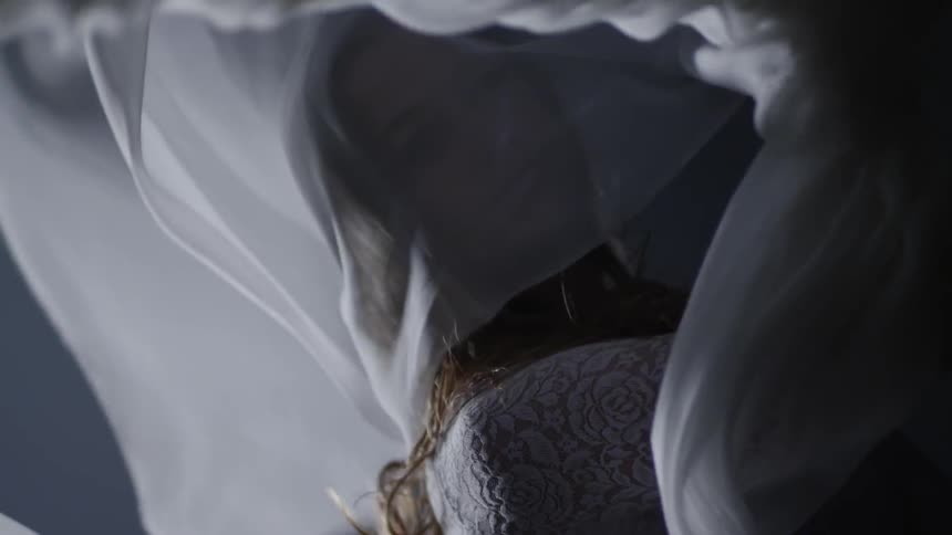 White fabric billows around a woman as she moves and dances
