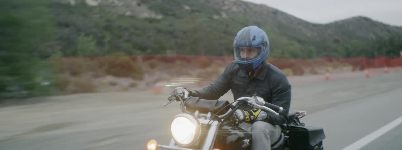 Man rides a motorcycle across the road
