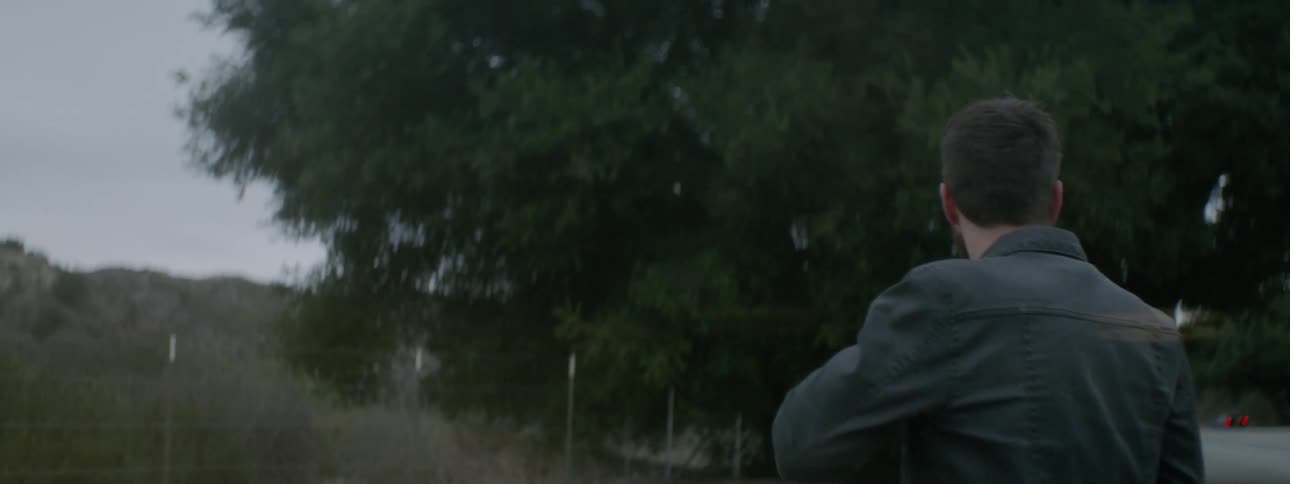 A man getting off a motorcycle on a trail