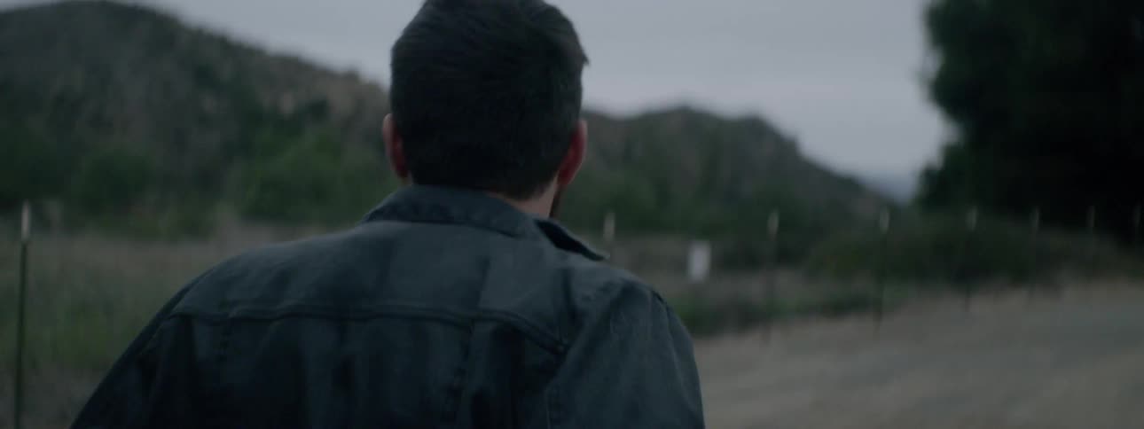 A man walks around a dirt road looking lost