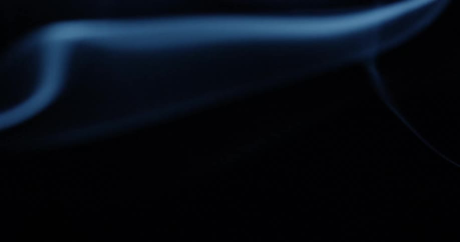 Blue smoke trail on a dark room