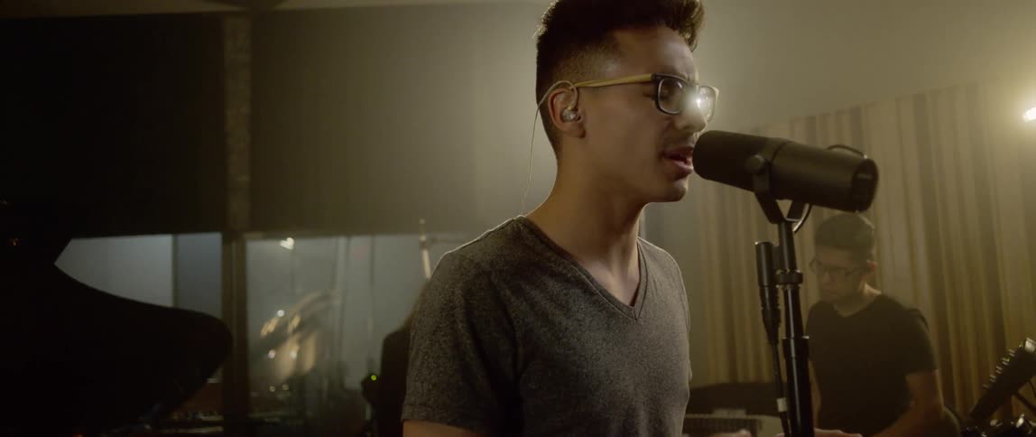 A man singing into a microphone in a studio