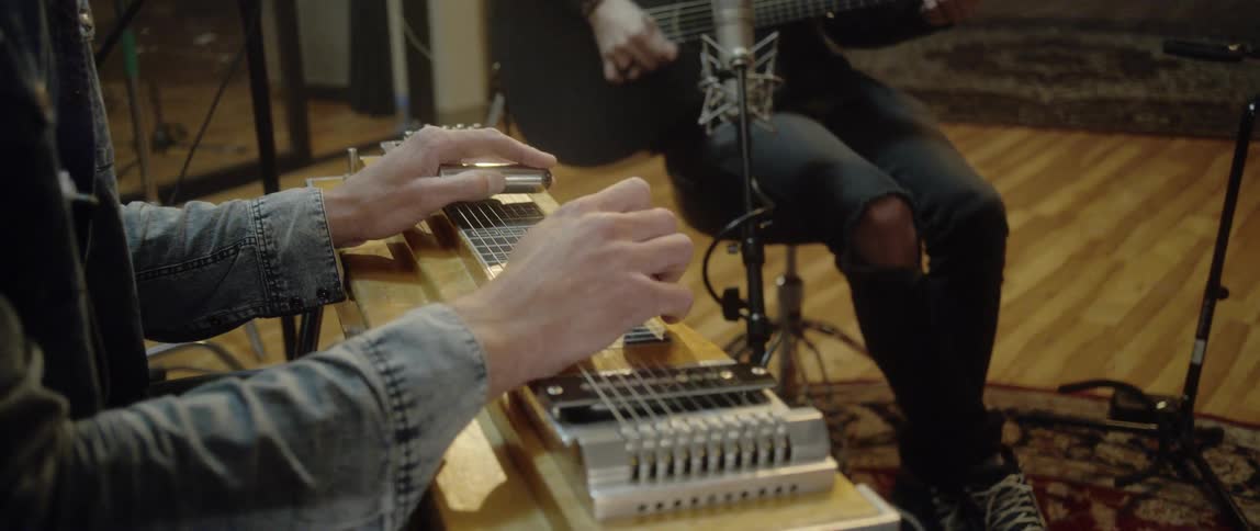 A pair of musicians playing instruments together indoors