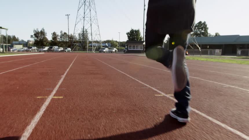 A person runs down a read track