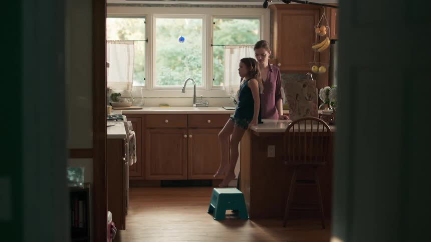 Filming woman and girl unpacking groceries in kitchen