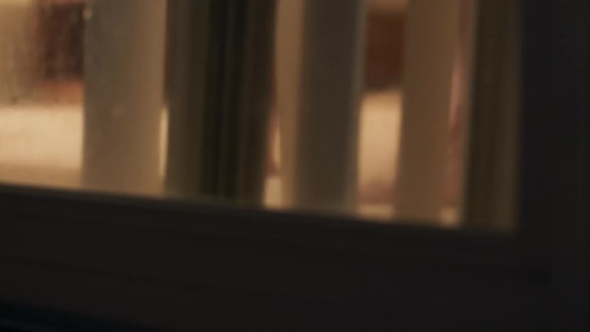 A person moves vertical blinds then walks away