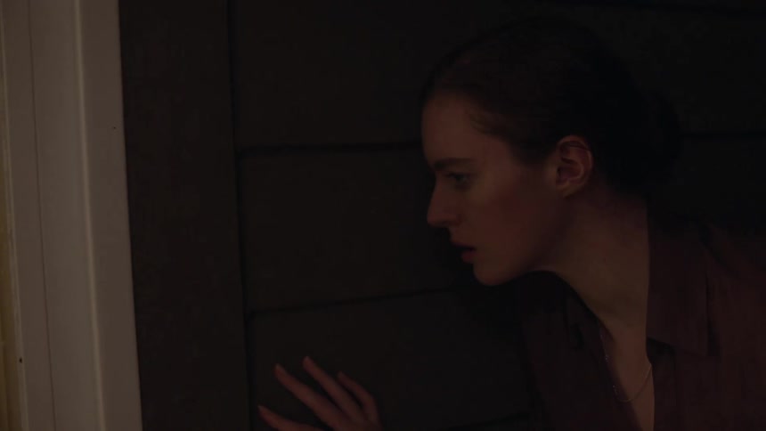 Woman listens at the door and tries to peep through window