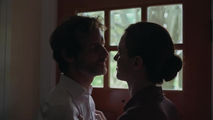 A wife kisses her husband goodbye