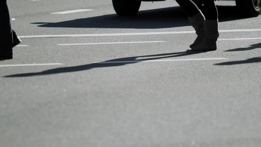 Some people walk across asphalt