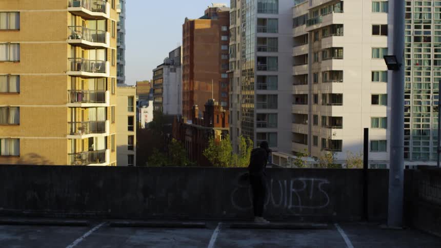 A man leans against a concrete barrier