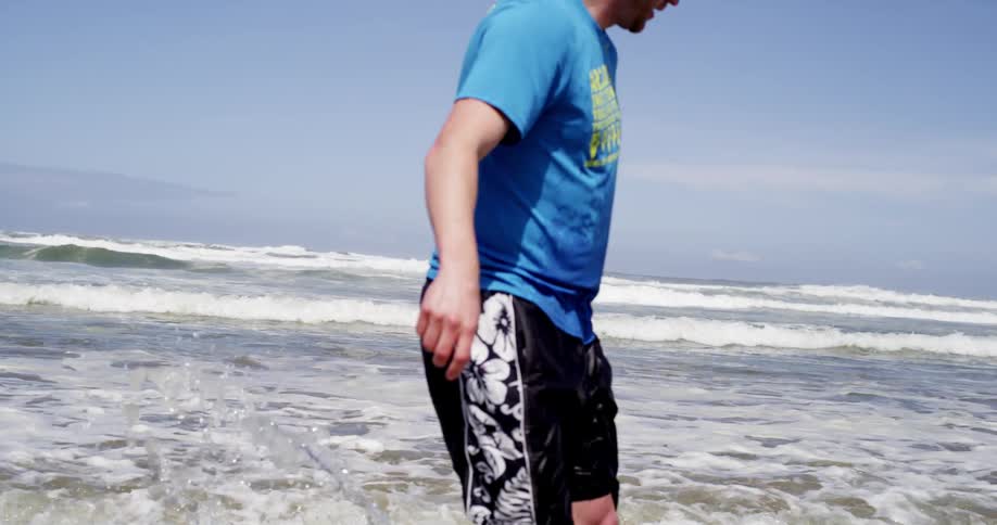A man surfs near the beach on a sunny day