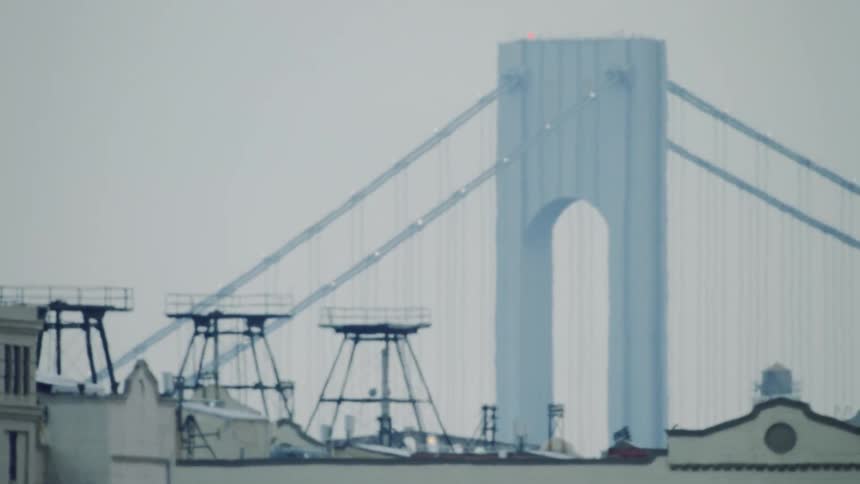 Heat wave distortion of suspension bridge above building rooftops