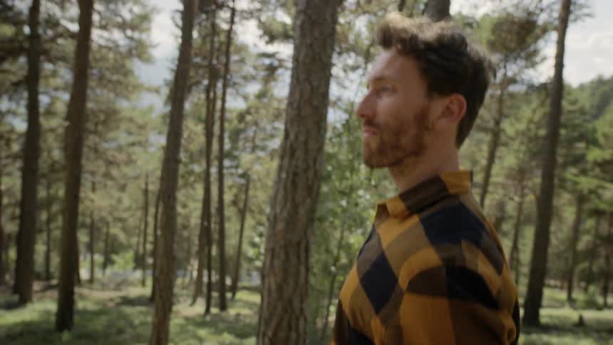 Man walks down the hill in the forest