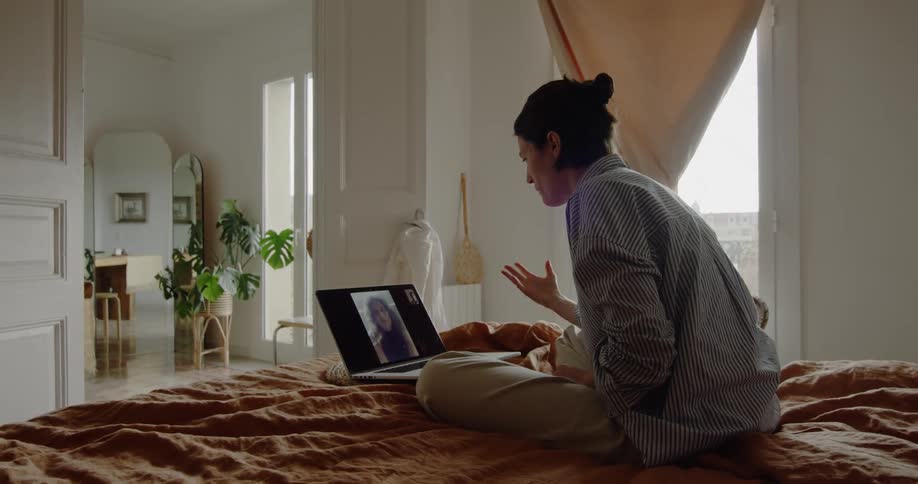 A woman chats with a friend using her laptop