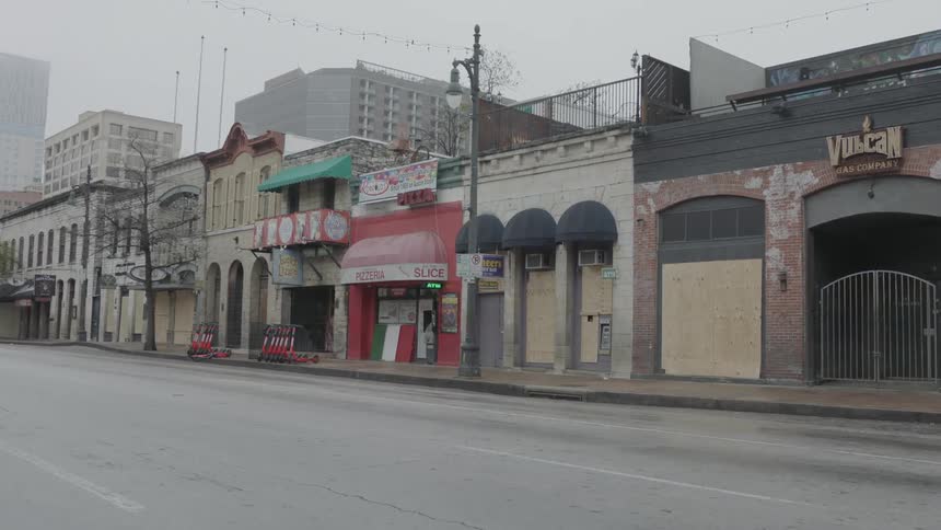 Travelling along empty streettoward downtown past small stores