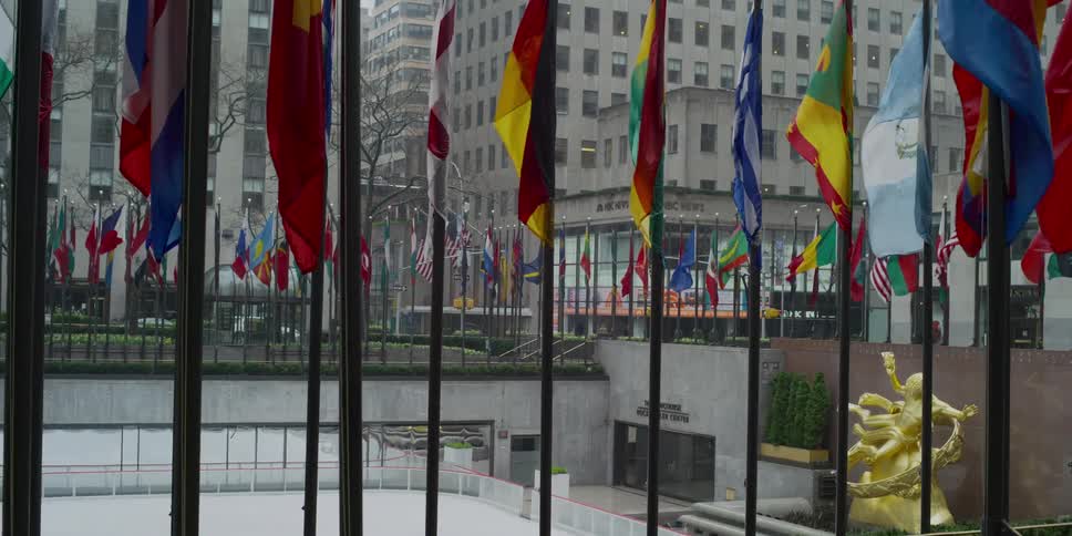An outdoor ice rink in the city is surrounded by flags