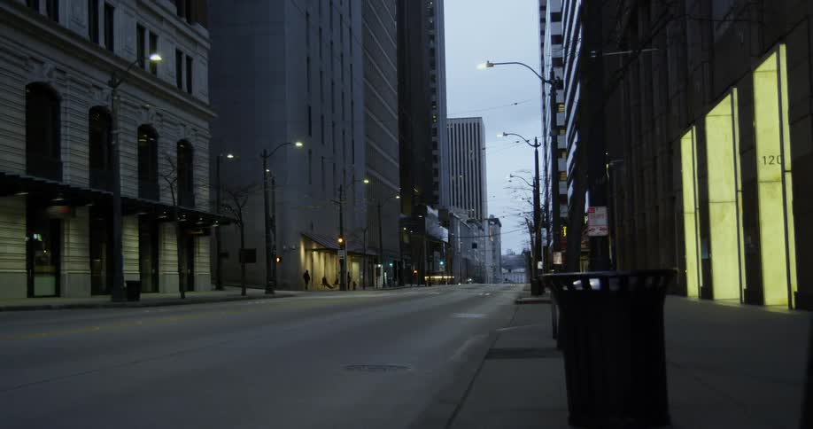 A city street with buildings on each side and in the background